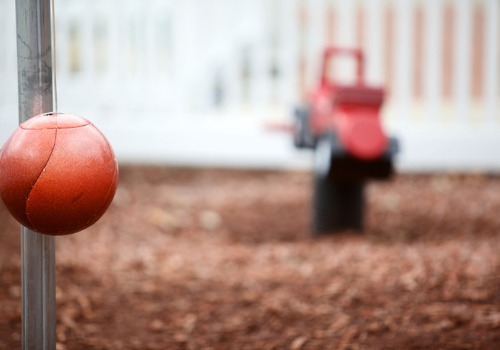 tetherball pole with playground in a blurred background