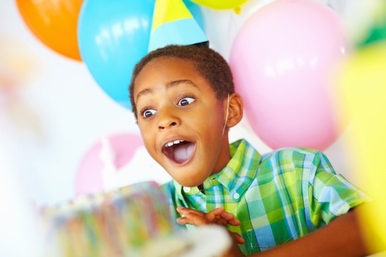 Kid Smiling Behind a Cake, Enjoying Birthday Parties for East Peoria IL