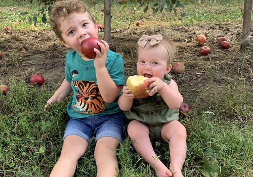 Two children snack on fresh apples from Tanners Orchard. When you are searching for Kids Activities in Freeport IL, make the drive to Tanners Orchard.