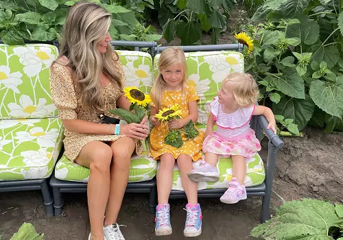 A woman and her daughters pose with sunflowers at Tanners Orchard, which offers numerous Kids Activities for Champaign IL residents