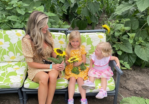 A woman and her daughters hold sunflowers from the Sunflower Fields in Illinois found at Tanners Orchard