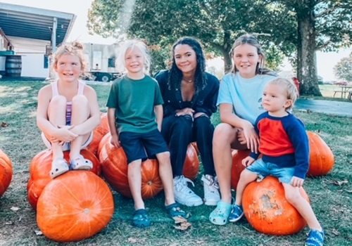 A family sits posing on pumpkins at Tanners Orchard, which also offers Apple Picking in Illinois